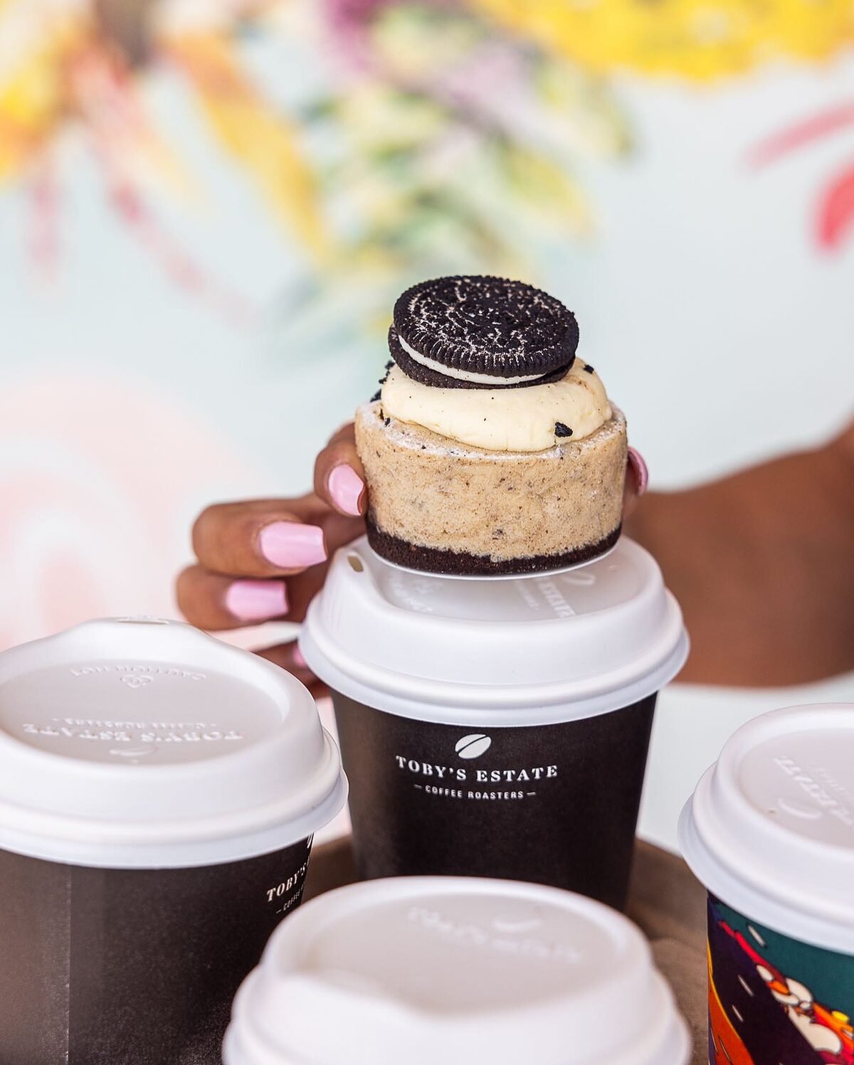 An Oreo cupcake balanced on takeaway coffee cups at Soft Sip